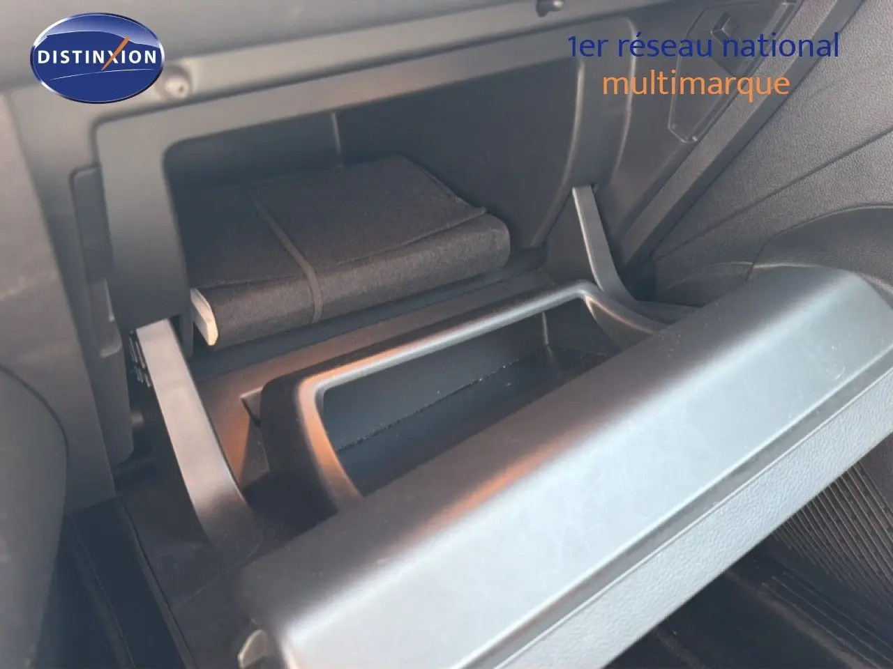 Coffre à gants ouvert du Renault Captur 2022 bleu marine fumé, montrant un carnet de bord à l'intérieur.