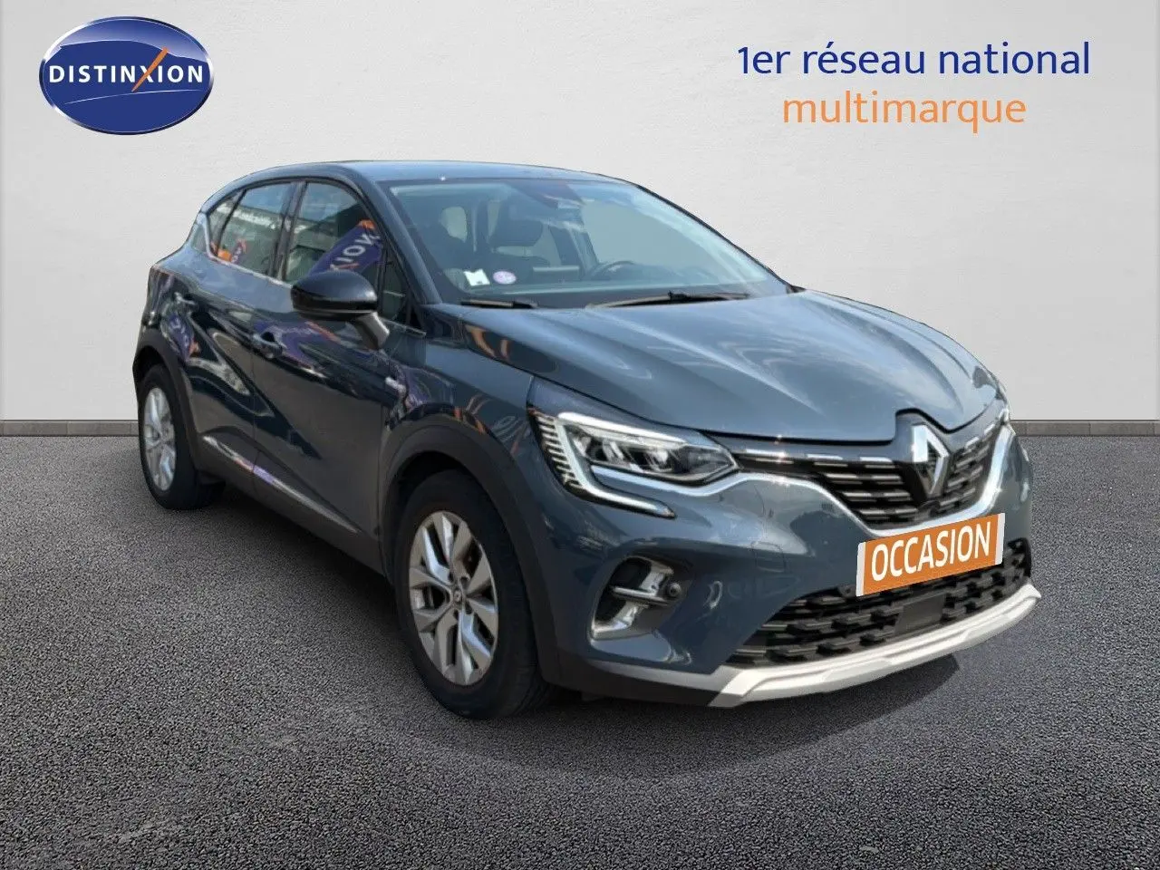 Renault Captur bleu marine fumé en 3/4 avant droit, SUV compact avec feux LED et calandre distinctive.