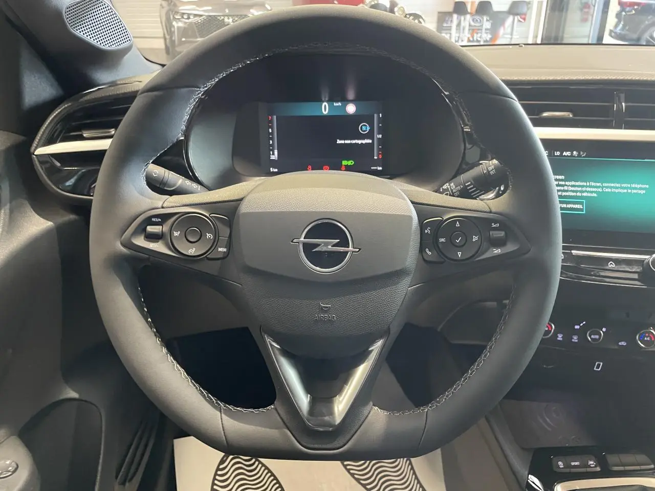 Vue frontale du volant en cuir noir de l'Opel Corsa 2026 avec tableau de bord numérique et écran tactile multimédia.