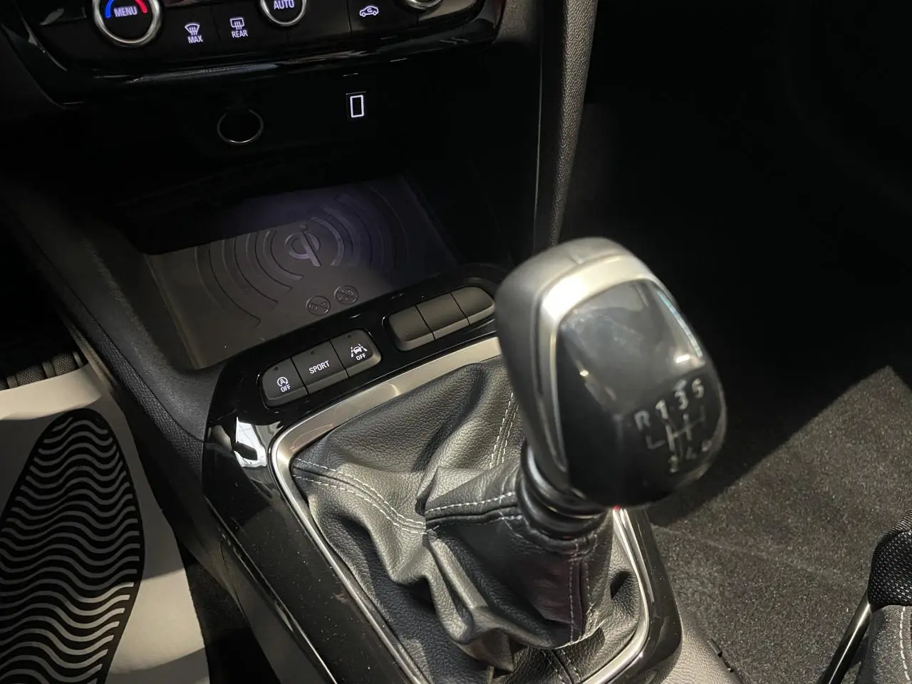 Gros plan sur la console centrale de l’Opel Corsa gris, mettant en valeur le levier de vitesses manuel et les boutons de contrôle.