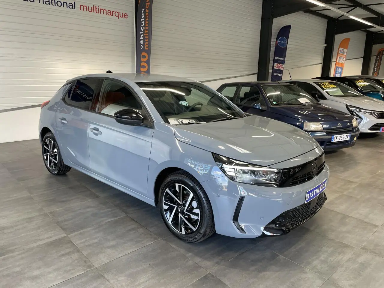 Opel Corsa gris Grafik vue 3/4 avant droit en intérieur, jantes alliage diamantées et rétroviseurs noirs.