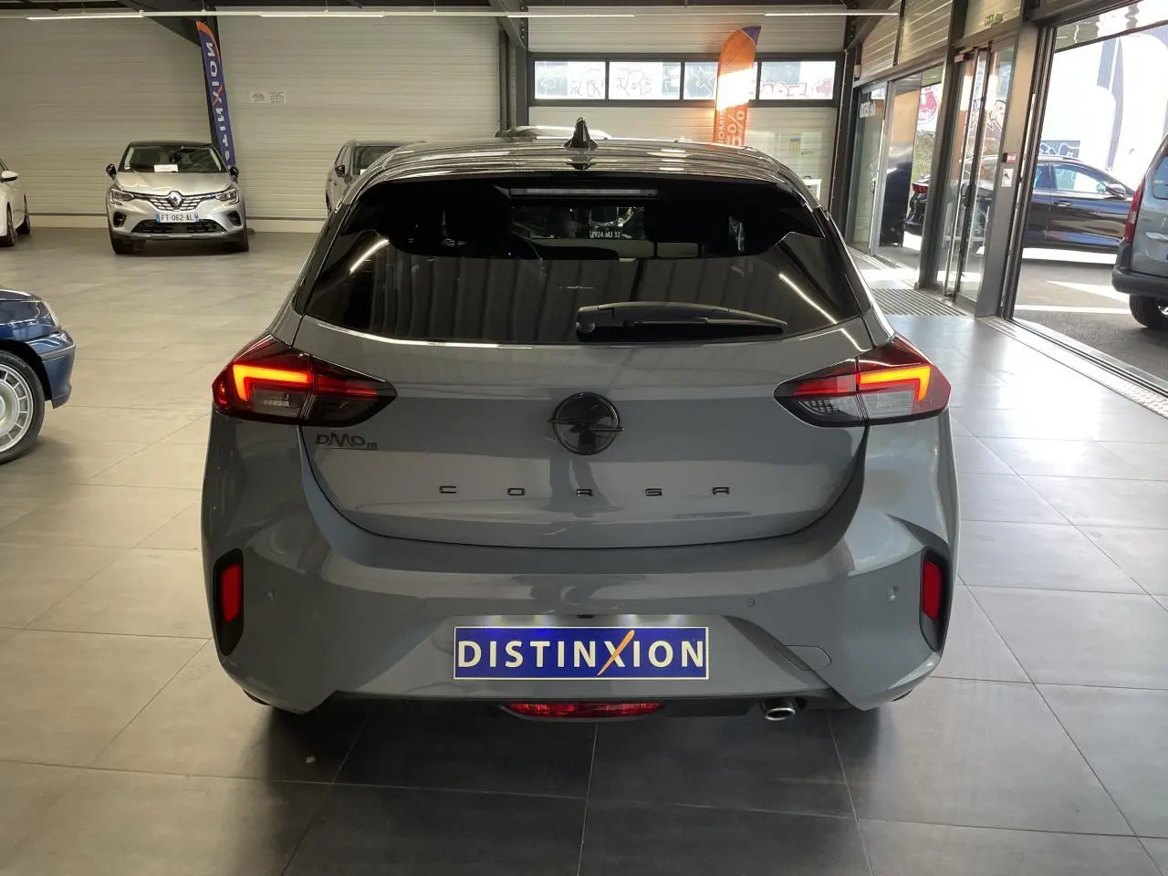 Vue arrière d'une Opel Corsa gris Grafik avec feux LED allumés dans un showroom.