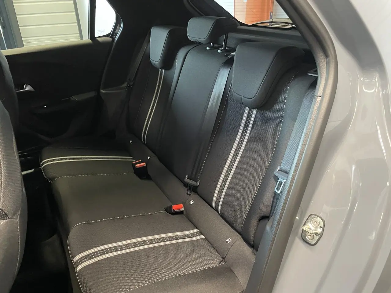 Vue intérieure côté droit sur la banquette arrière noire avec surpiqûres blanches de l’Opel Corsa gris 2026.