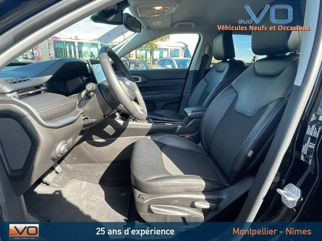 Intérieur avant droit du Jeep Compass noir 2023, sièges cuir noirs avec accoudoir central et tableau de bord moderne.