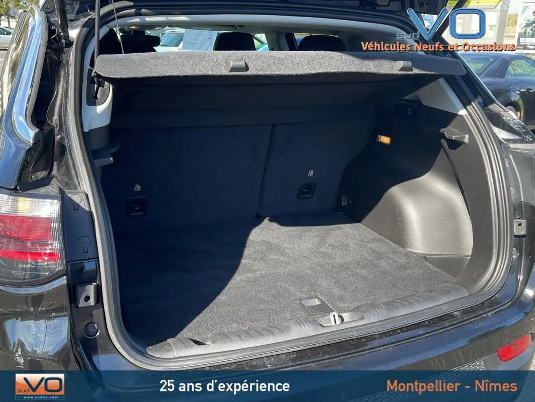 Coffre ouvert vu de l'arrière d'un Jeep Compass noir 2023, montrant l'espace de chargement propre et spacieux.
