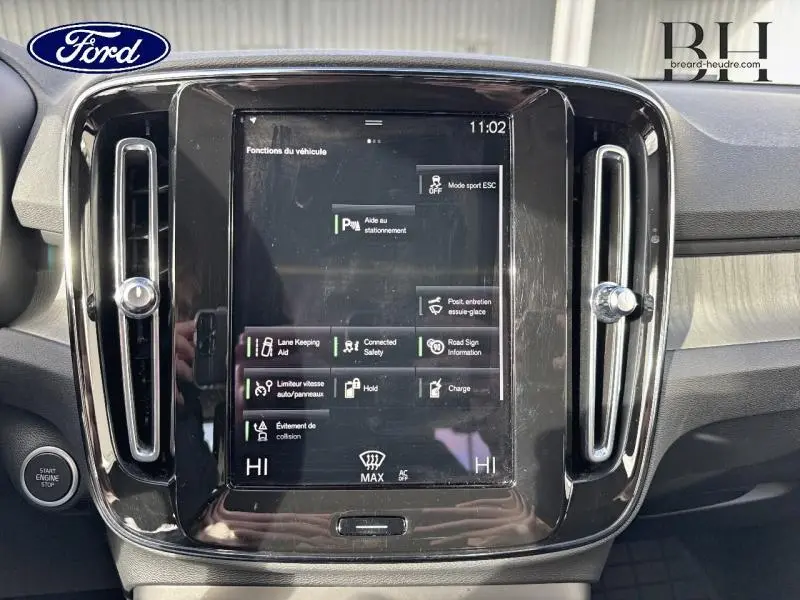 Vue rapprochée de l’écran tactile central noir du tableau de bord du Volvo XC40 Bleu Denim, avec commandes affichées.