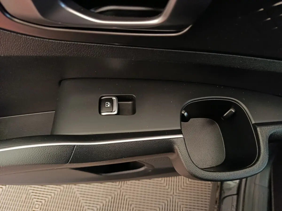 Détail de la commande de verrouillage de porte et porte-gobelet côté conducteur intérieur noir du Kia Sorento 2023 hybride rechargeable.