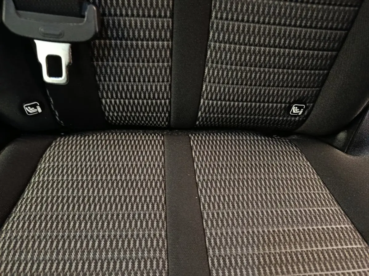 Gros plan sur la banquette arrière noire texturée du Kia Sorento 2023 avec fixation Isofix visible.