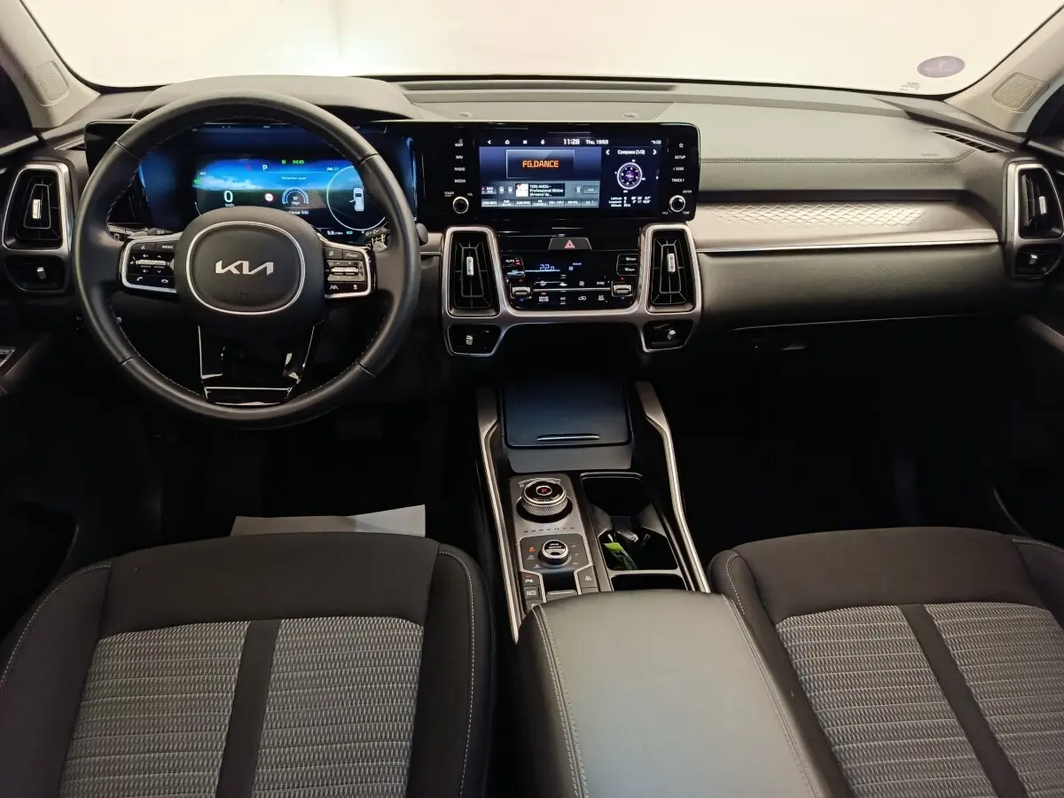 Vue intérieure avant du tableau de bord du Kia Sorento 2023 avec écran tactile et volant cuir noir.