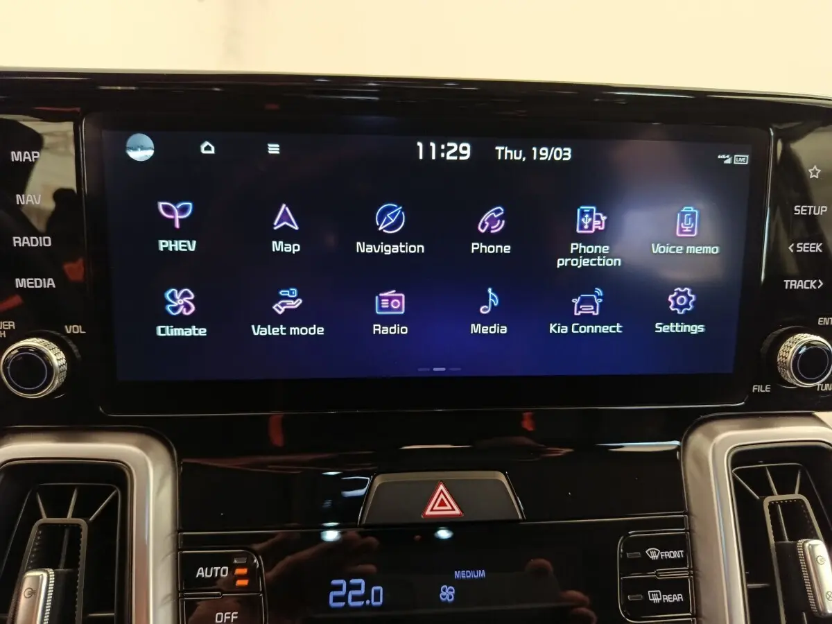 Écran tactile central du tableau de bord du Kia Sorento noir 2023 affichant les options de navigation et climatisation.