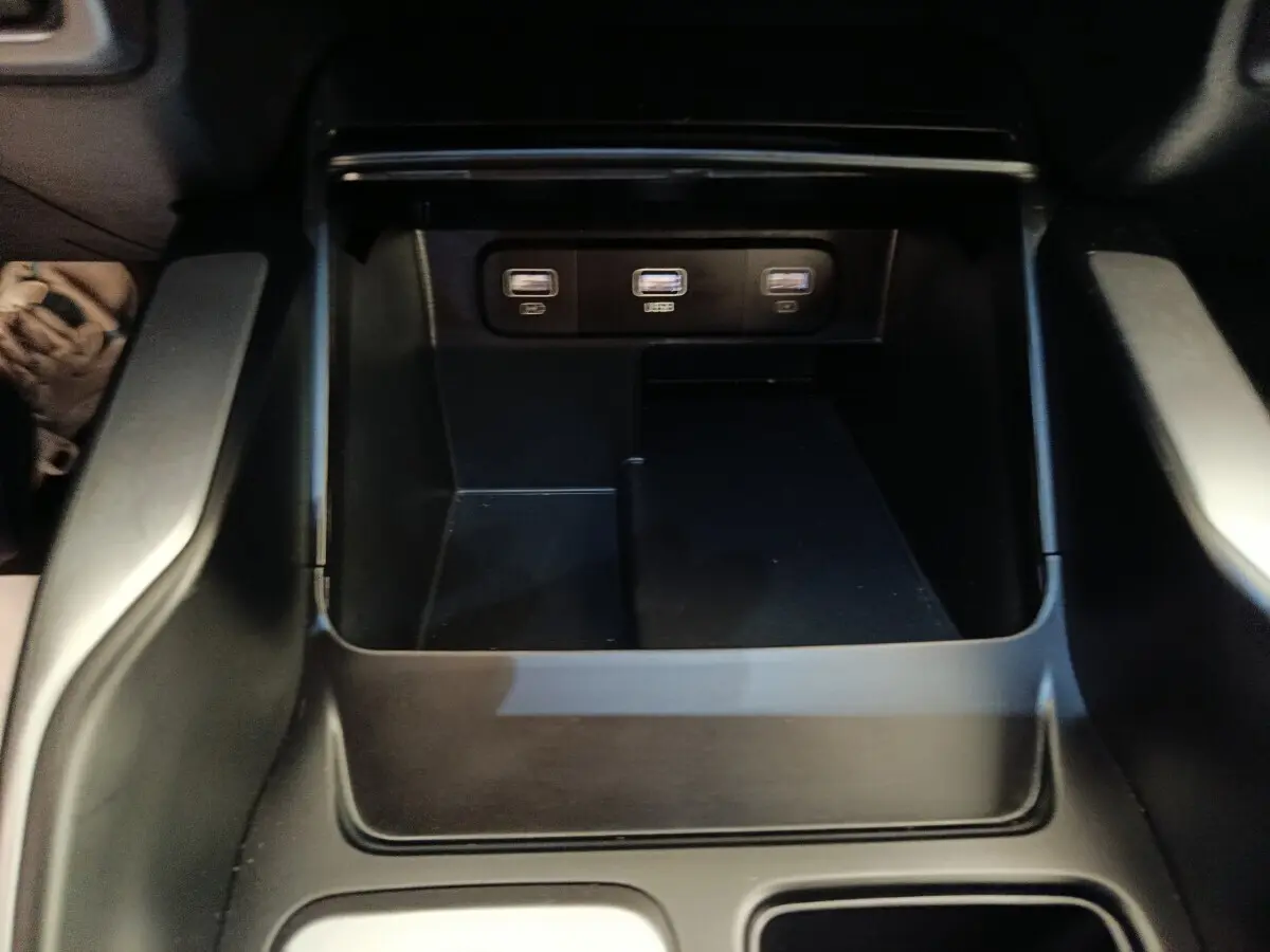 Gros plan sur la console centrale noire du Kia Sorento 2023, montrant trois ports USB alignés.