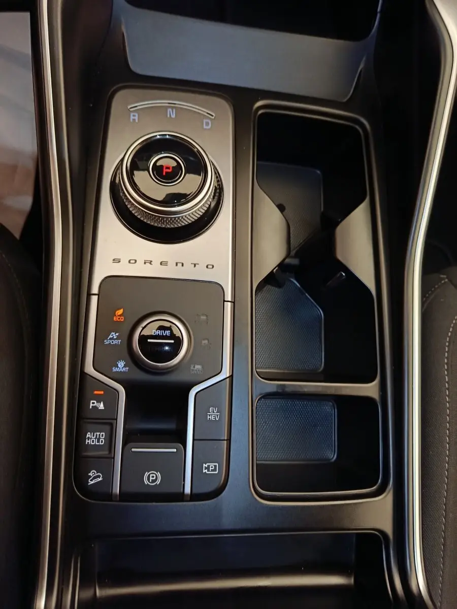 Gros plan sur la console centrale noire du Kia Sorento 2023 avec sélecteur rotatif de boîte auto et commandes de modes de conduite.