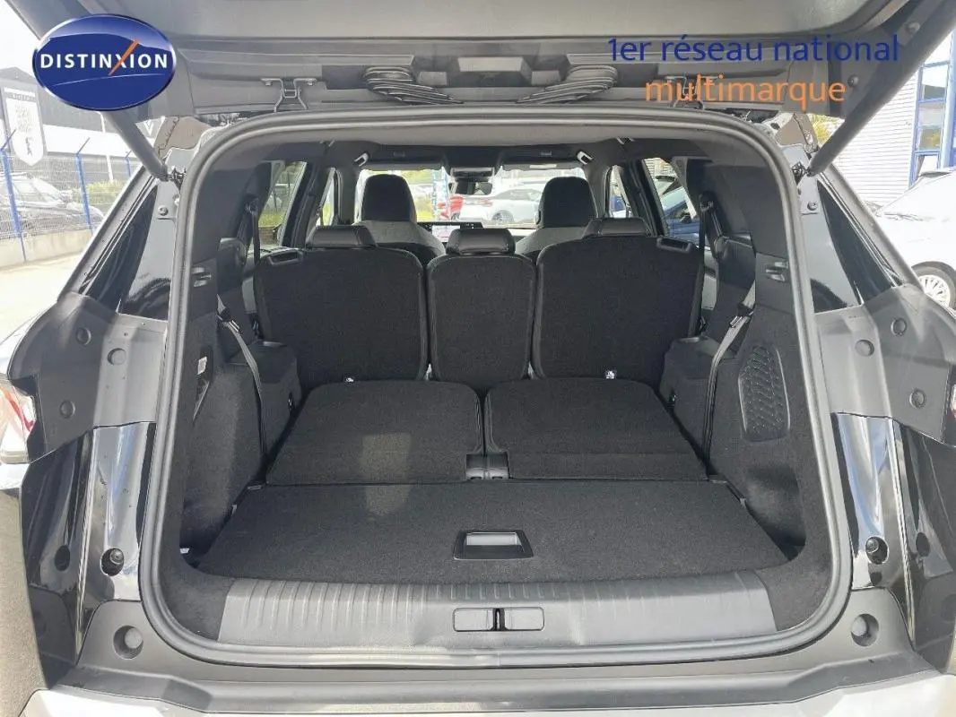 Coffre ouvert vue arrière du Peugeot 5008 noir 2025 avec sièges arrière rabattus offrant un grand espace de chargement.