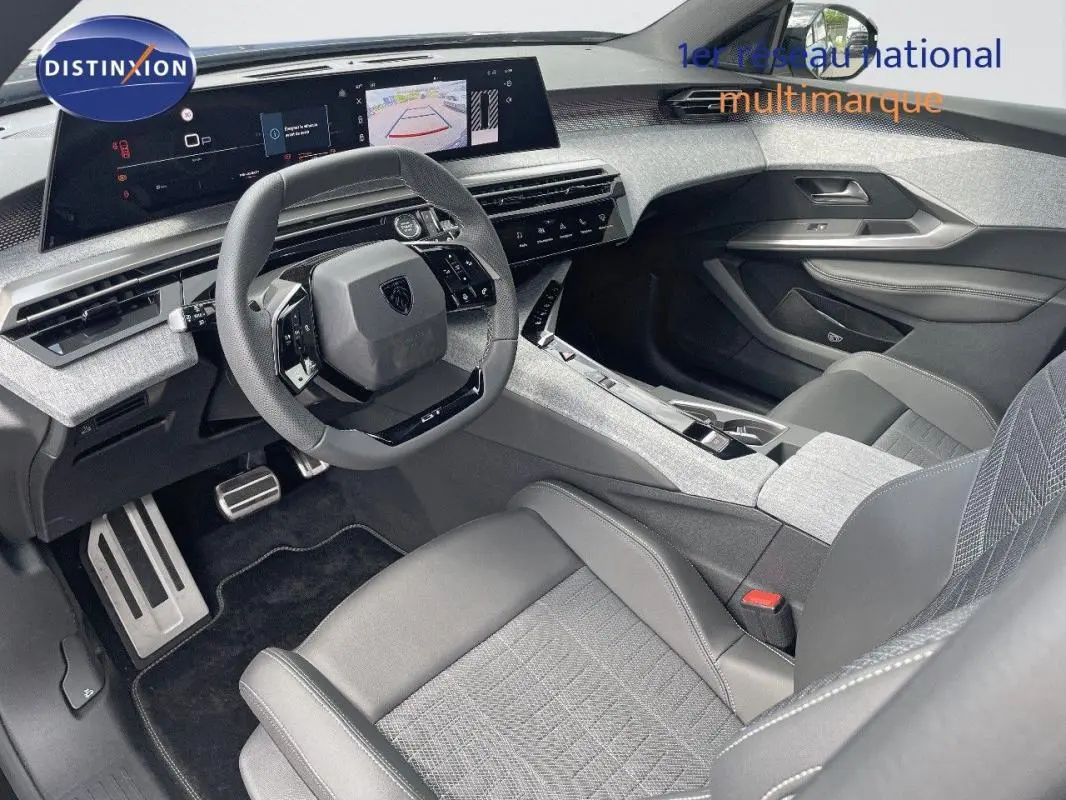 Vue intérieure avant droite du Peugeot 5008 1.2 Hybrid 145ch GT avec tableau de bord numérique et sièges gris cuir tissu.