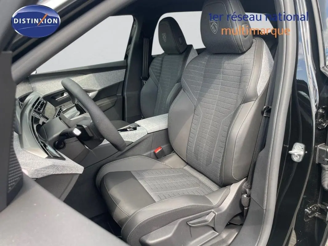Vue intérieure côté conducteur du Peugeot 5008 noir 2025, mettant en valeur les sièges en cuir et tissu avec logo Peugeot brodé.