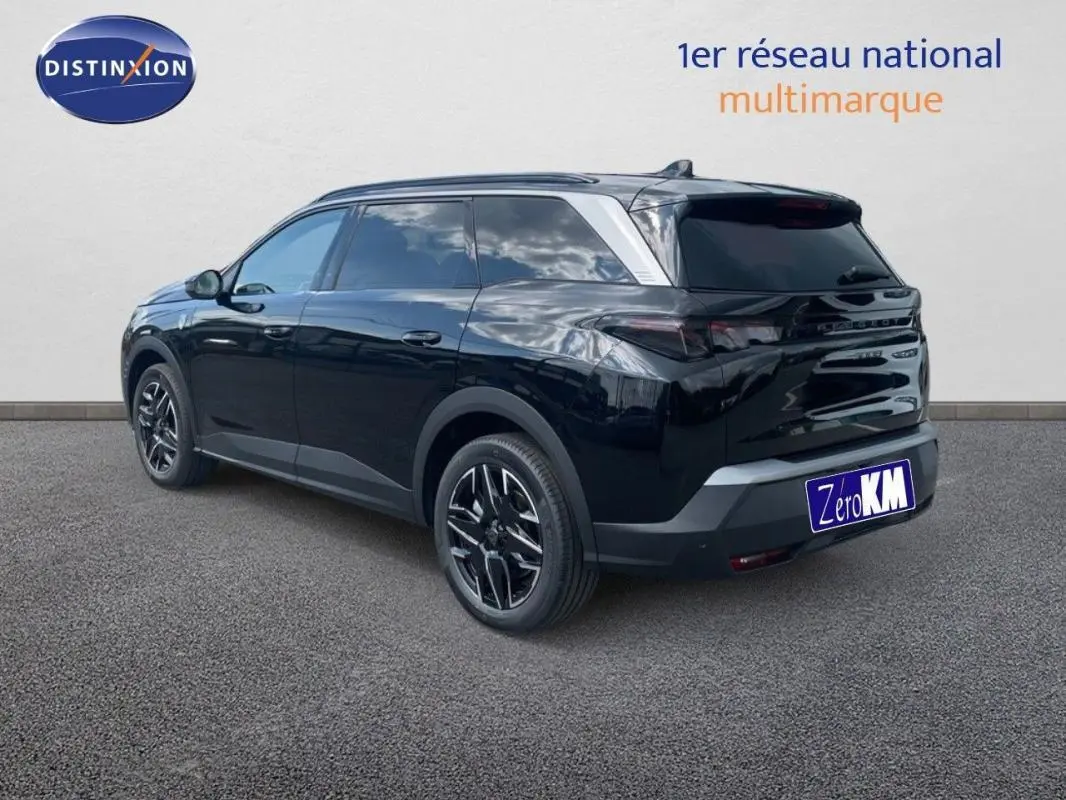 Peugeot 5008 noir en 3/4 arrière droit, avec jantes aluminium et barres de toit visibles.