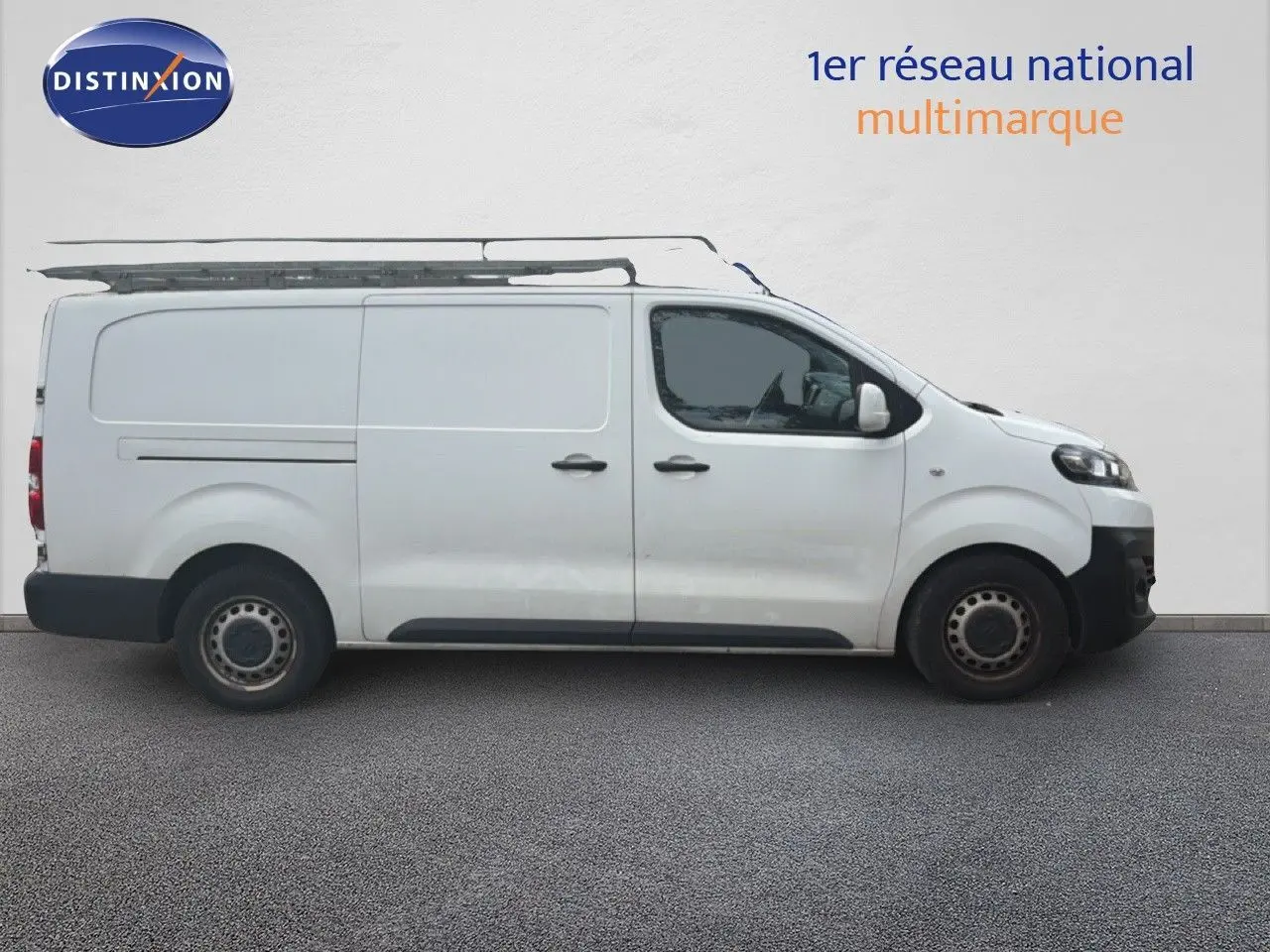 Vue de profil côté droit d’un Citroën Jumpy XL blanc utilitaire avec galerie de toit, sur fond neutre.