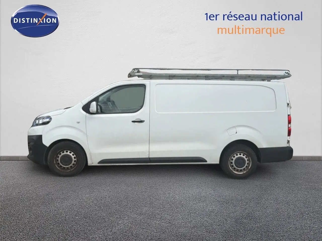 Vue de profil côté gauche d’un utilitaire Citroën Jumpy XL blanc avec galerie de toit métallique.