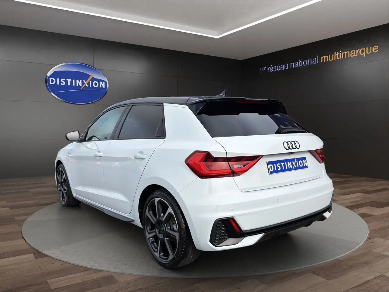 Audi A1 Sportback blanc vue 3/4 arrière droit avec toit noir et aileron de toit distinctif.
