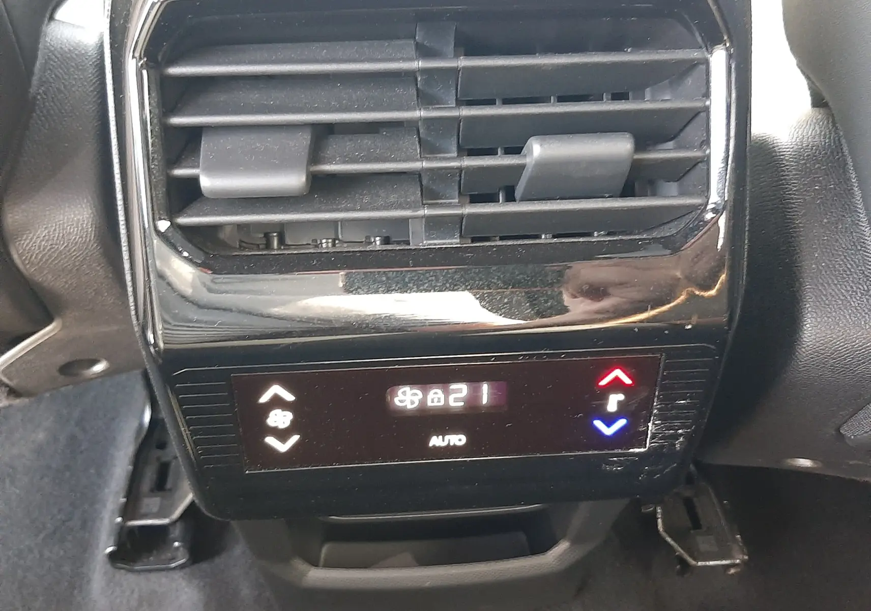 Vue rapprochée de la commande de climatisation arrière noire du Peugeot 5008 gris Artense, affichant 21°C en mode auto.