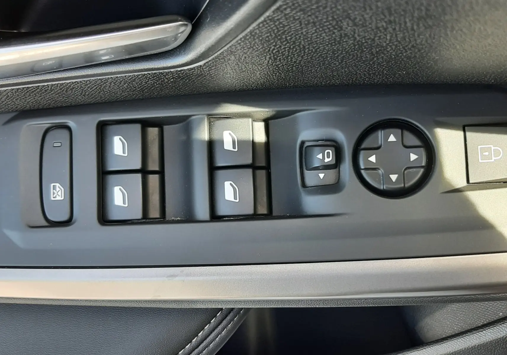 Gros plan sur la commande des vitres et rétroviseurs côté gauche intérieur d’un Peugeot 5008 gris Artense 2025.