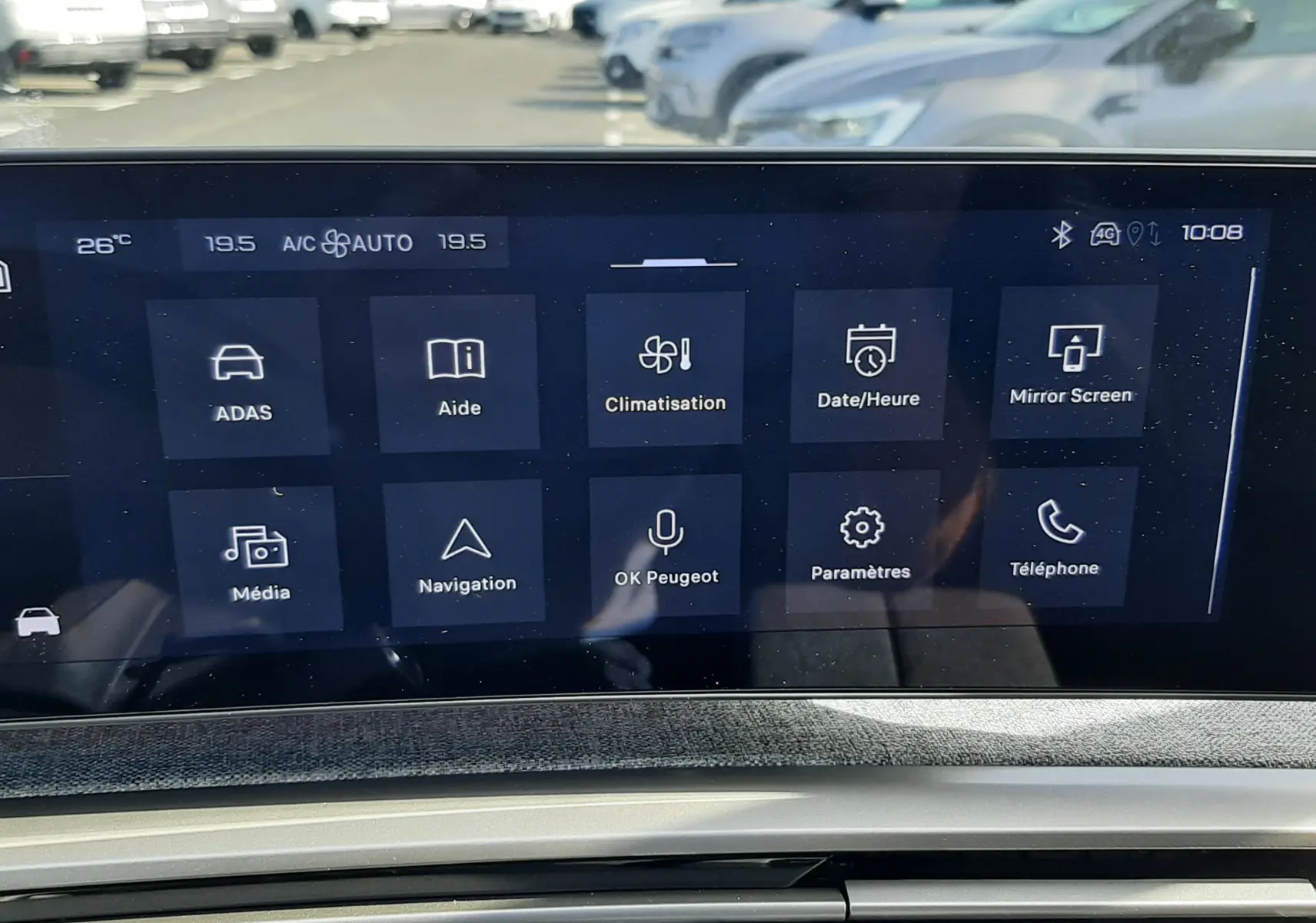 Vue rapprochée de l’écran tactile central et de la console d’une Peugeot 5008 gris Artense, affichant les options de climatisation et navigation.