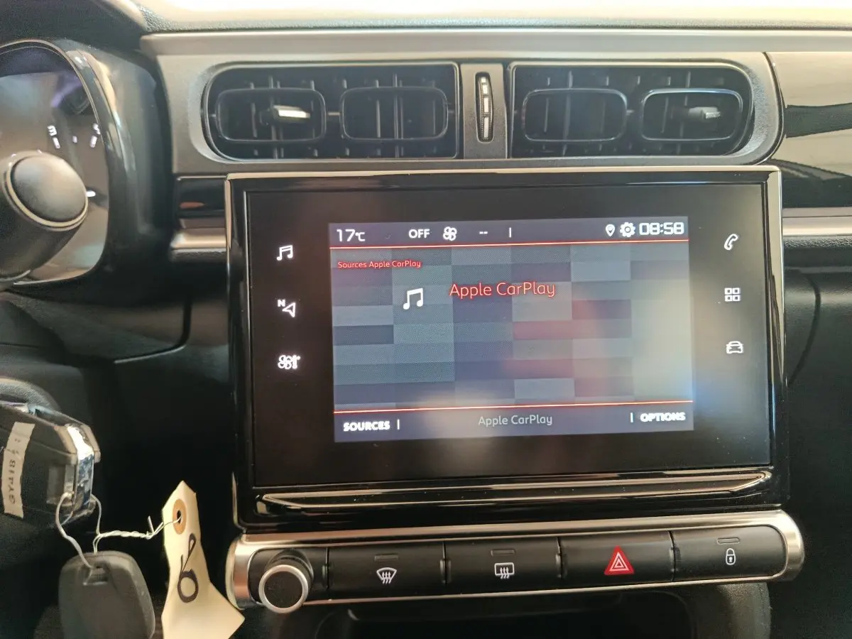 Vue rapprochée du tableau de bord de la Citroën C3 2024 gris foncé, avec écran tactile affichant Apple CarPlay.