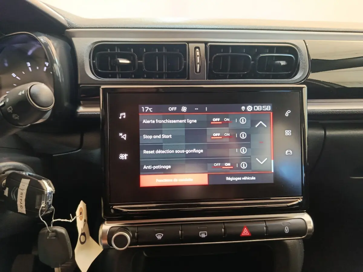 Écran tactile central allumé du tableau de bord d'une Citroën C3 gris foncé, vue frontale rapprochée.