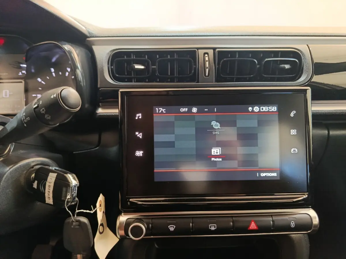 Vue rapprochée du tableau de bord central tactile de la Citroën C3 2024, avec commandes et écran allumé.