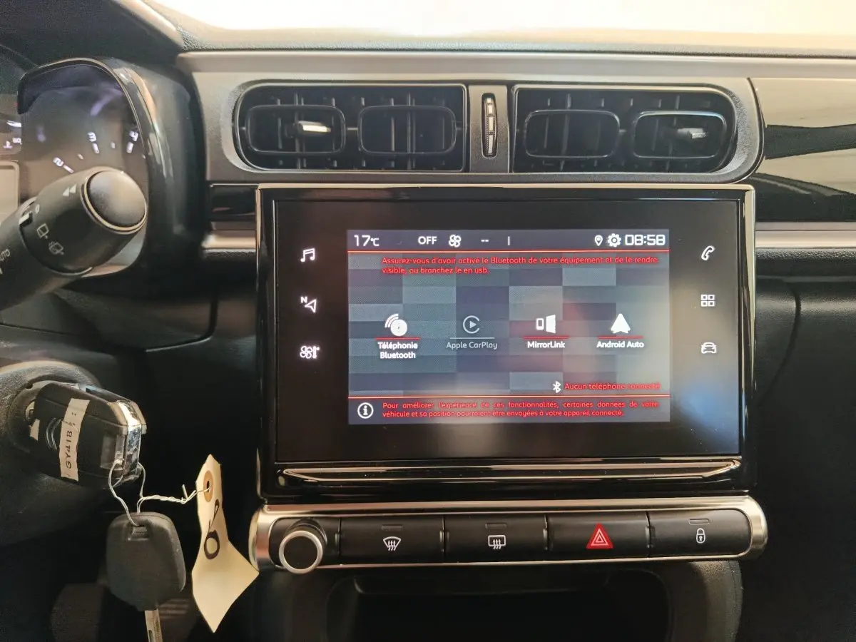 Vue rapprochée du tableau de bord de la Citroën C3 2024 gris foncé, avec écran tactile central et commandes climatisation.
