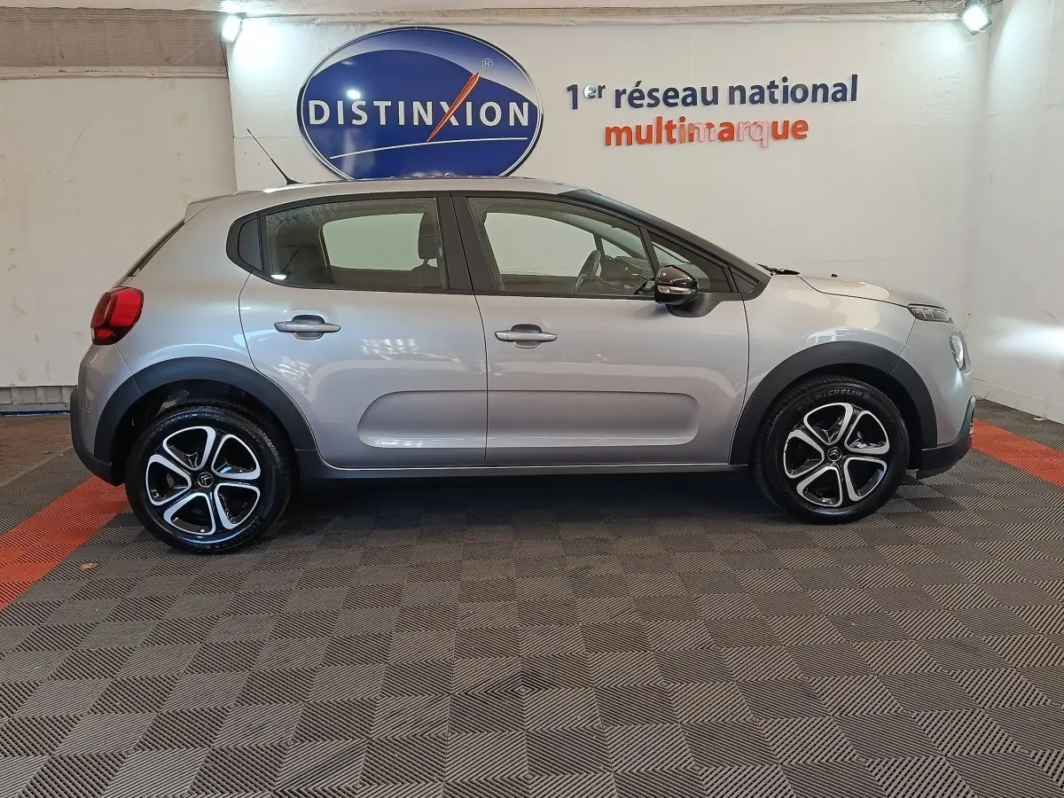 Profil droit d'une Citroën C3 gris foncé 2024, avec jantes alliage et protections noires sur les passages de roues.