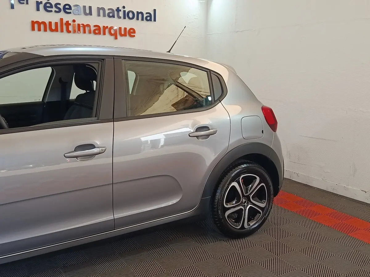 Vue latérale droite d'une Citroën C3 gris foncé 2024, mettant en valeur les jantes stylisées et les poignées de porte ton caisse.