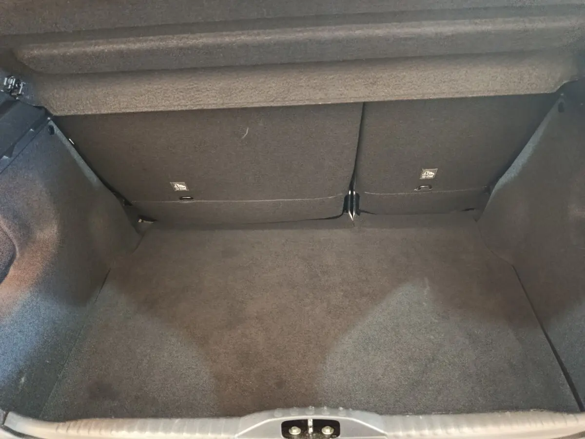 Coffre vide vu de face d'une Citroën C3 gris foncé, montrant la banquette arrière rabattable et le revêtement intérieur.