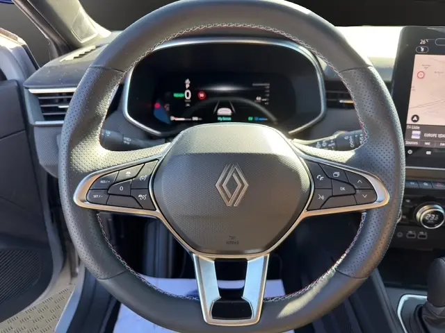 Vue rapprochée du volant cuir noir de la Renault Clio Esprit Alpine E-Tech 2025 avec tableau de bord numérique et écran tactile.