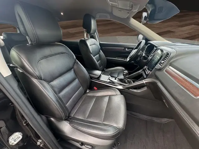 Intérieur noir cuir du Renault Koleos 2017, vue côté conducteur montrant sièges et console centrale avec boîte manuelle.