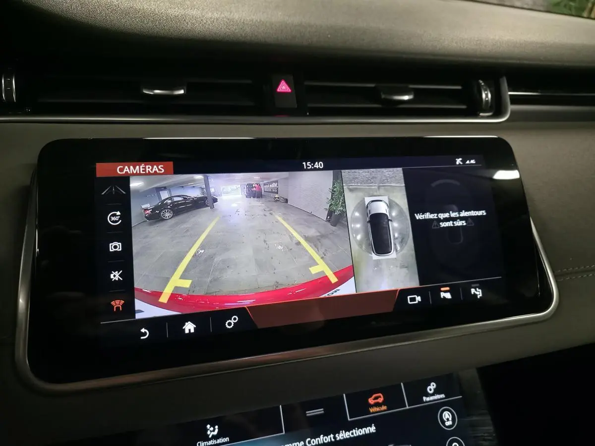 Écran tactile intérieur montrant la caméra de recul et vue 360° d’un Range Rover Evoque rouge en parking.