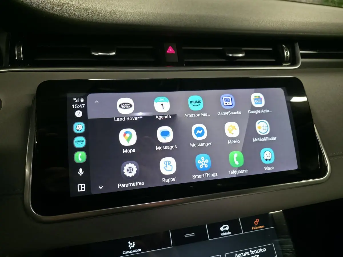 Écran tactile central du Range Rover Evoque 2019 affichant plusieurs applications connectées, intérieur sombre.