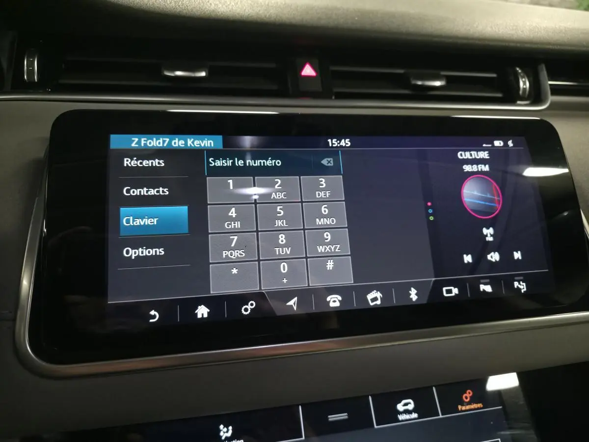 Écran tactile central du Range Rover Evoque rouge 2019 affichant le clavier téléphonique et la radio FM