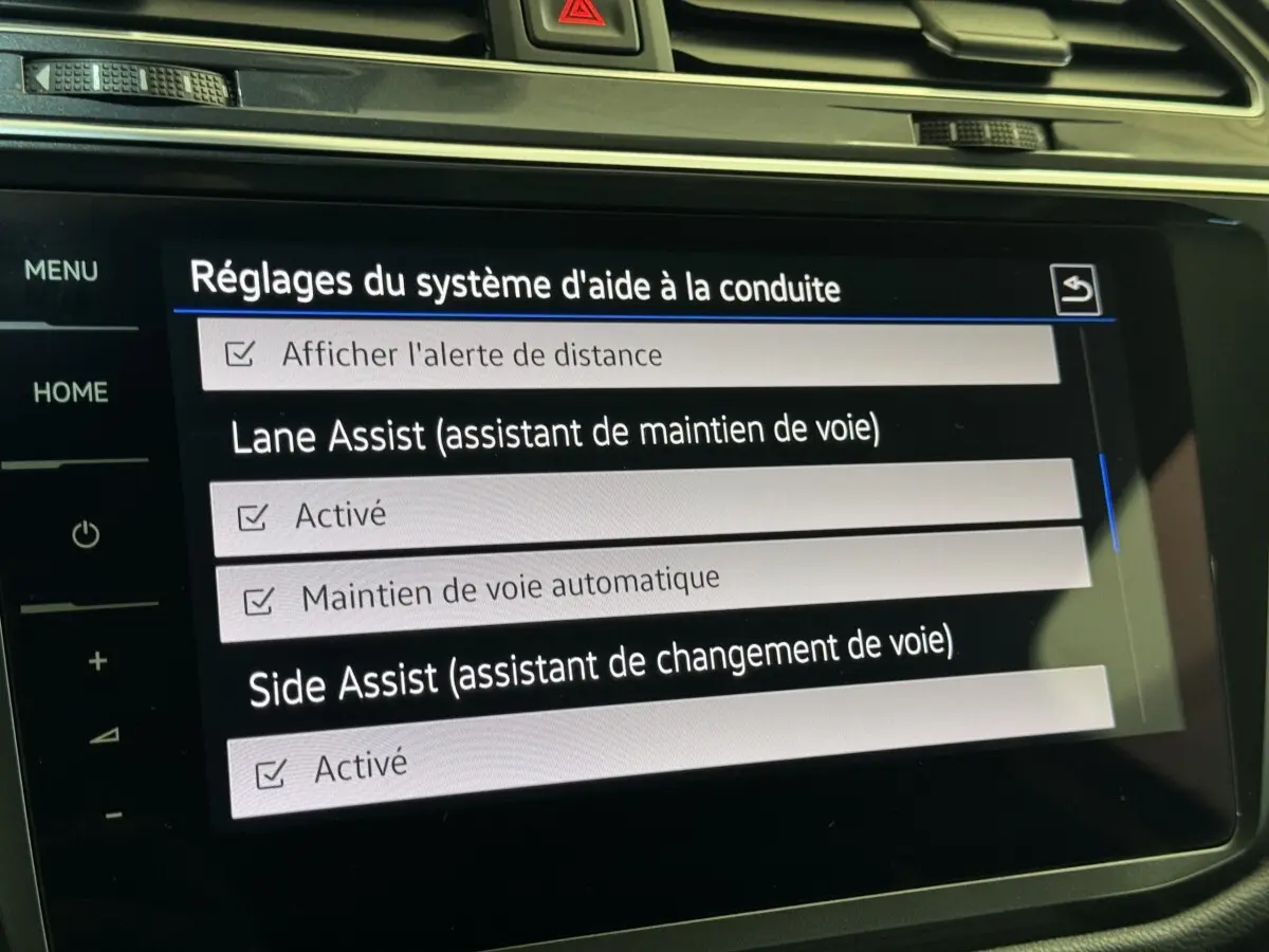 Écran tactile intérieur du Volkswagen Tiguan Allspace affichant les réglages d’aide à la conduite.