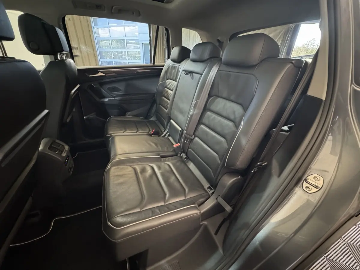Vue intérieure côté droit sur la banquette arrière en cuir noir du Volkswagen Tiguan Allspace gris foncé 2019.