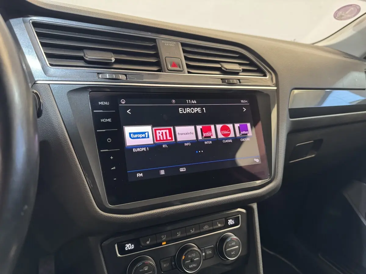 Vue intérieure du tableau de bord du Volkswagen Tiguan Allspace 2019 avec écran tactile affichant les radios, finition noire.