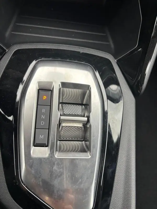 Gros plan sur la console centrale de la Peugeot 208 Hybrid 100 e-DCS6 Style 2025 gris, montrant la commande de boîte auto et les boutons de sélection.
