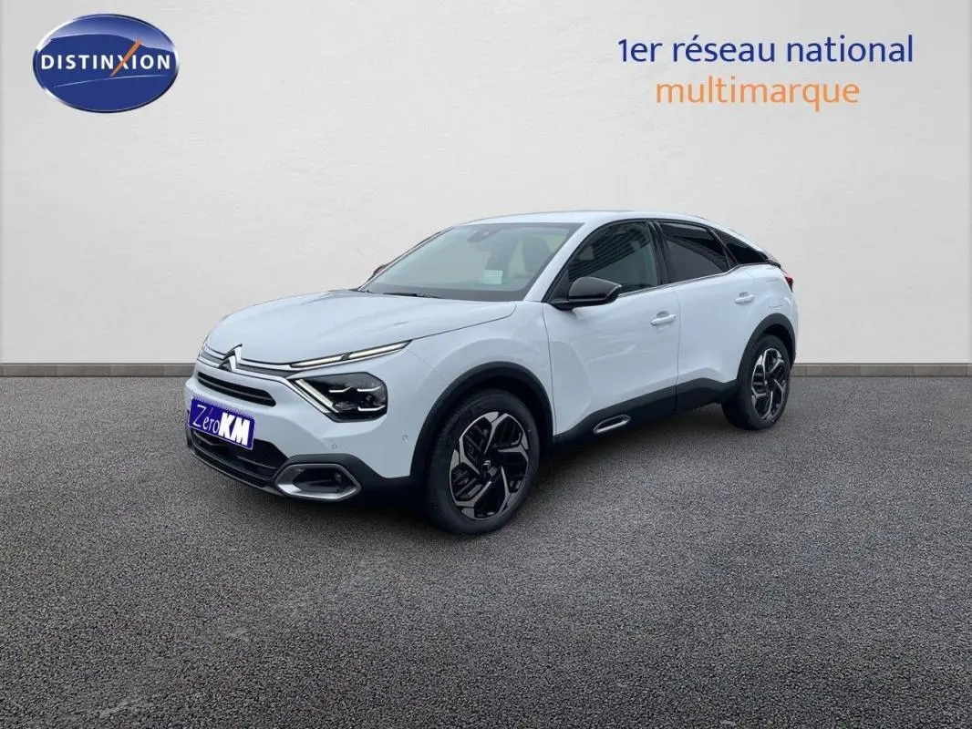 Citroën C4 blanc vue 3/4 avant droit, jantes aluminium et détails noirs contrastants sur carrosserie.