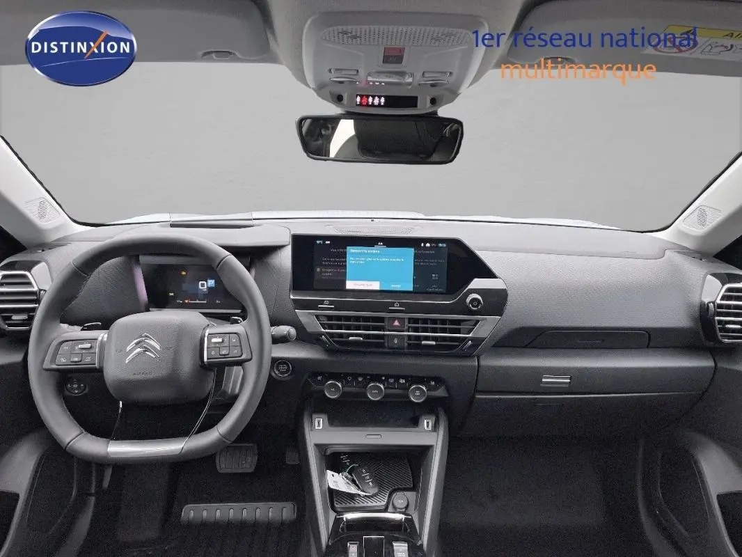 Vue frontale de l’intérieur noir du Citroën C4 2024 avec écran tactile central et volant cuir multifonction.