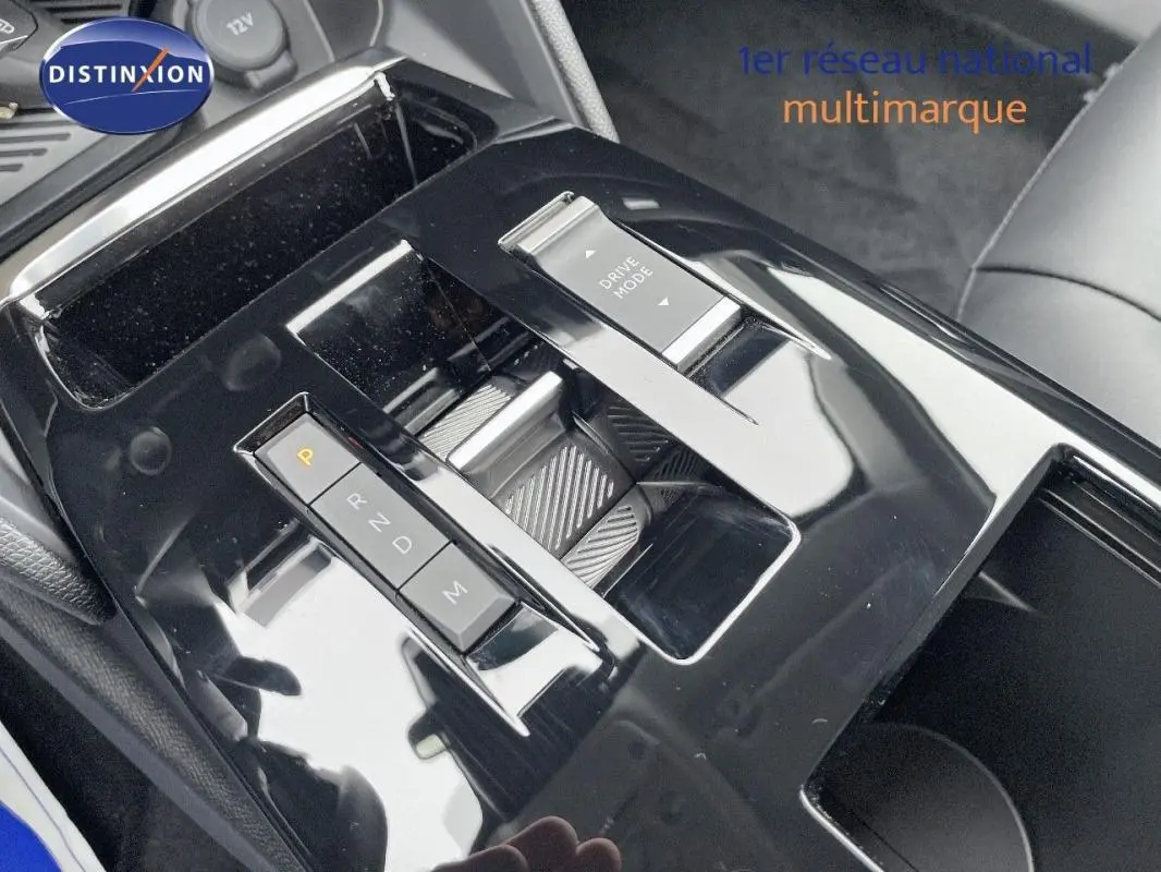 Gros plan sur la console centrale noire brillante de la Citroën C4 blanche, avec commande de boîte auto et bouton Drive Mode.