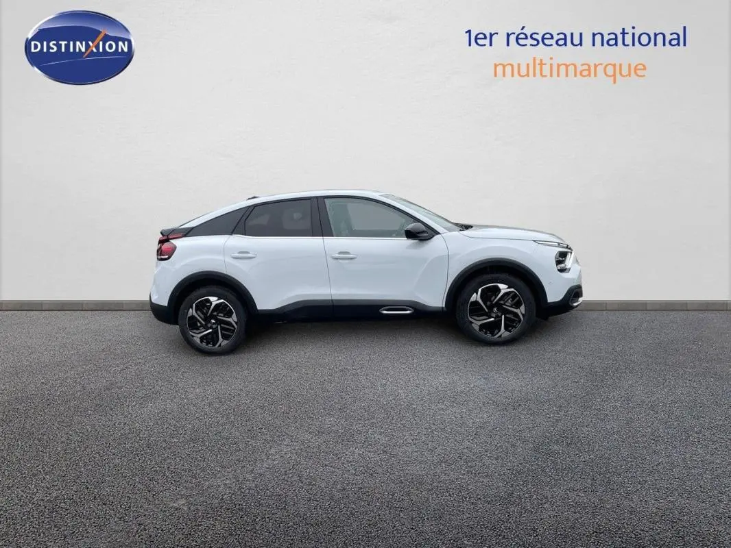 Profil droit d'une Citroën C4 blanche 2024 avec jantes aluminium et toit noir contrasté sur fond neutre.