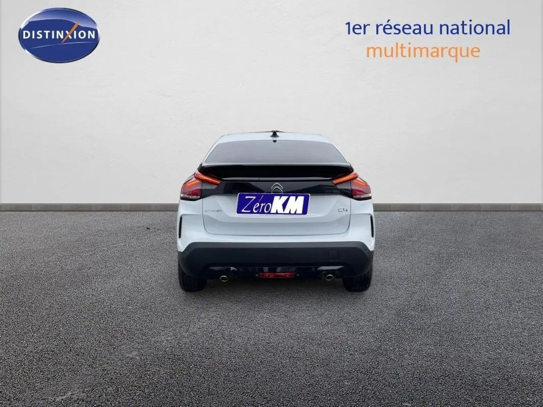 Vue arrière d'une Citroën C4 blanche 2024 avec feux arrière LED et double sortie d'échappement.