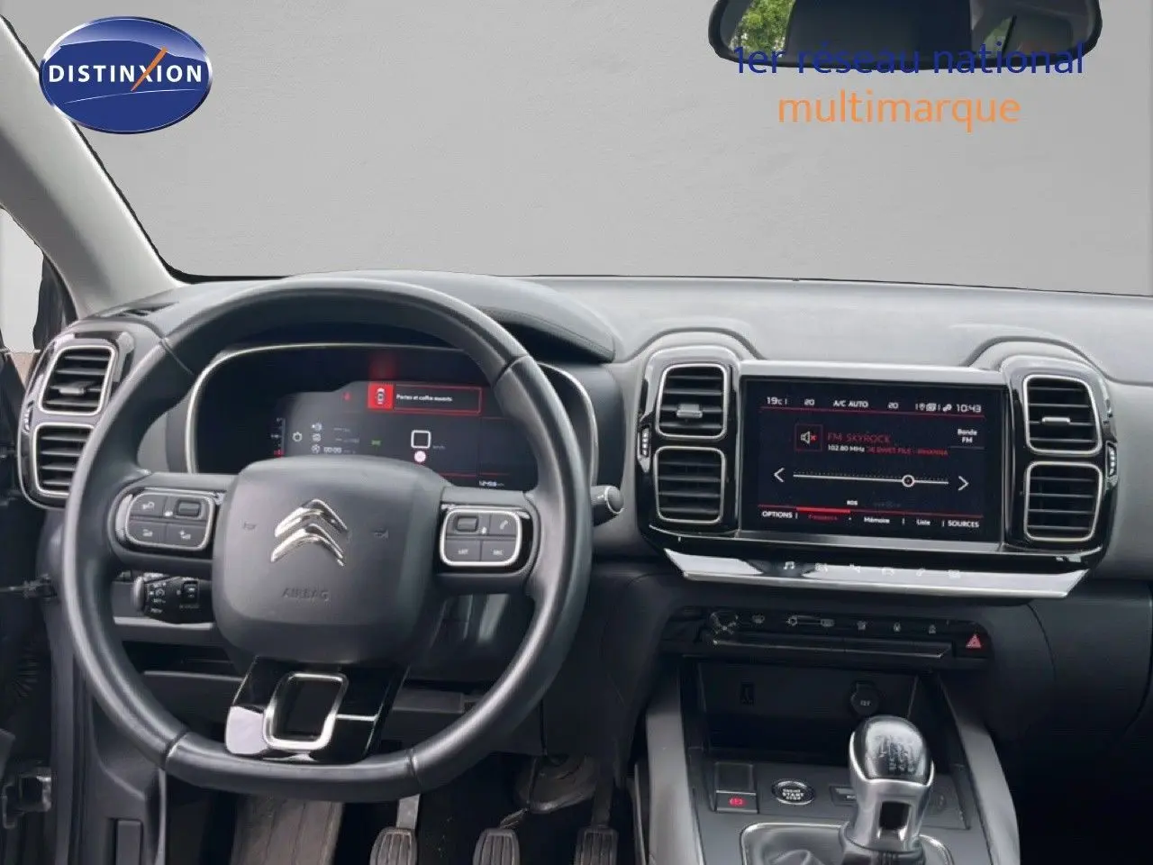 Vue intérieure du poste de conduite du Citroën C5 Aircross gris clair, avec tableau de bord numérique et écran tactile central.