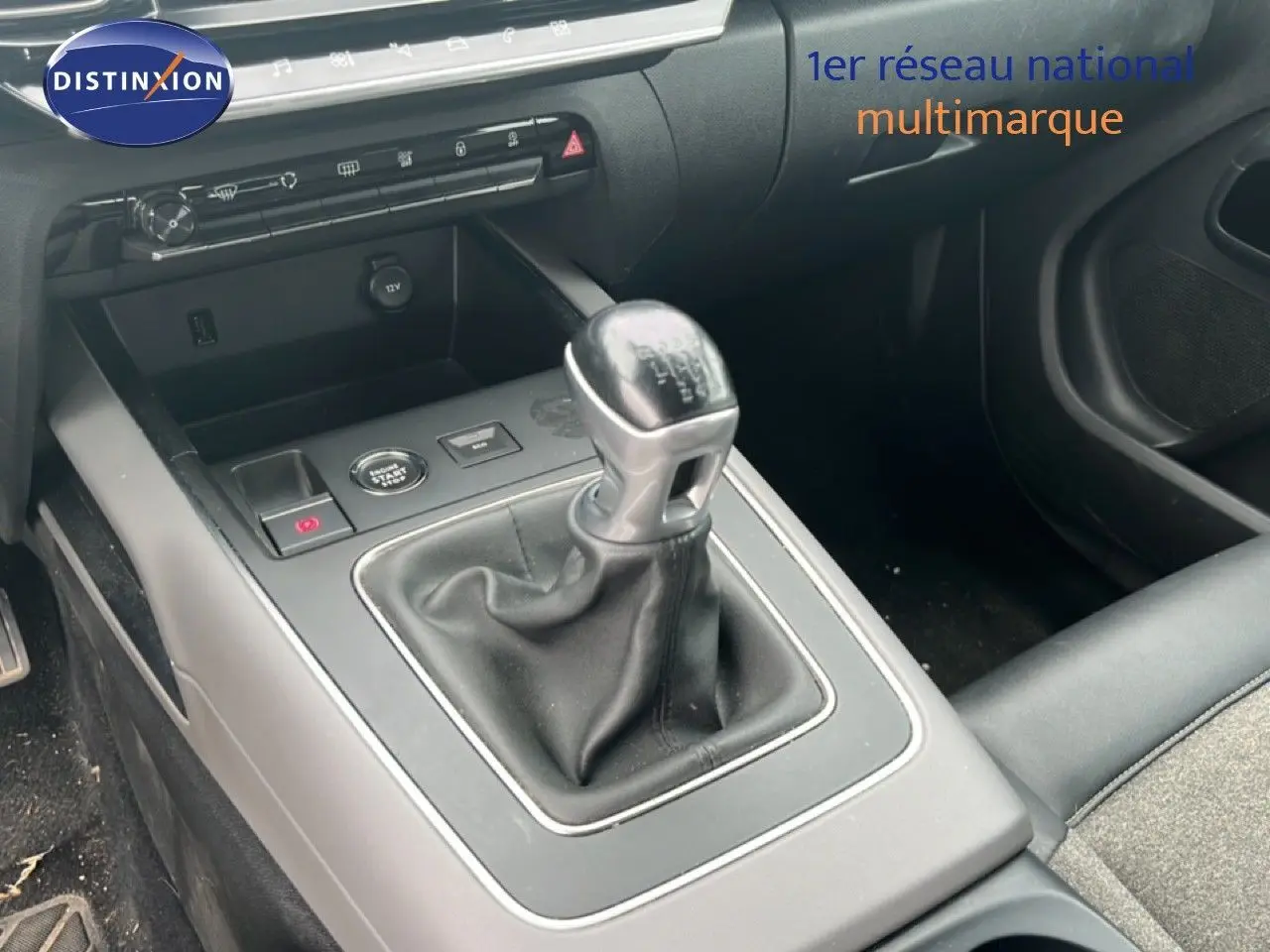 Gros plan sur la console centrale du Citroën C5 Aircross gris clair, mettant en valeur le levier de vitesses manuel et les commandes environnantes.