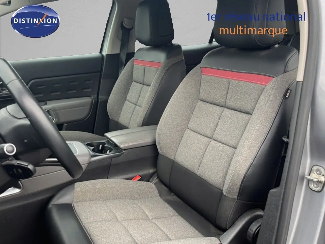 Vue intérieure côté conducteur du Citroën C5 Aircross gris clair, sièges tissu gris avec bande rouge et cuir noir.